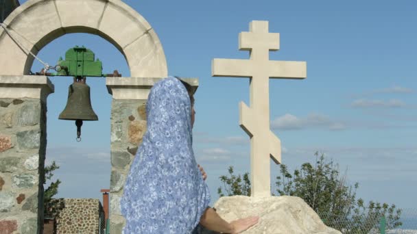 Religiös kvinna tittar på sten cross med hopp. Symbol för kyrkan, religion — Stockvideo