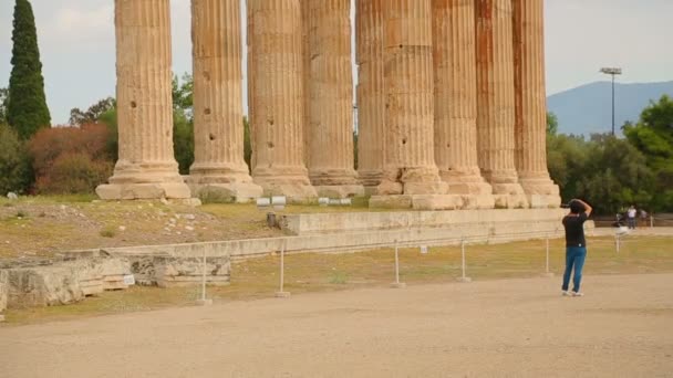 Hombre tomando fotos de columnas antiguas con capiteles sofisticados y arquitrabes — Vídeos de Stock