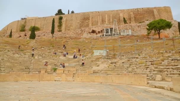 Många turister som tittar på gamla teatern Dionysos förblir, amphitheater säten — Stockvideo