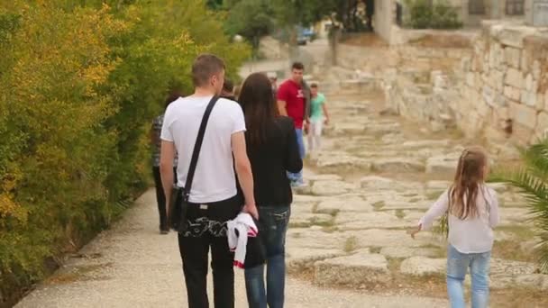 एथेंस, ग्रीस जुलाई, 2014: शहर में चलने वाले लोग। बेटी के साथ युवा माता-पिता चलना, रिसॉर्ट शहर में प्राचीन सड़क पर चलना — स्टॉक वीडियो