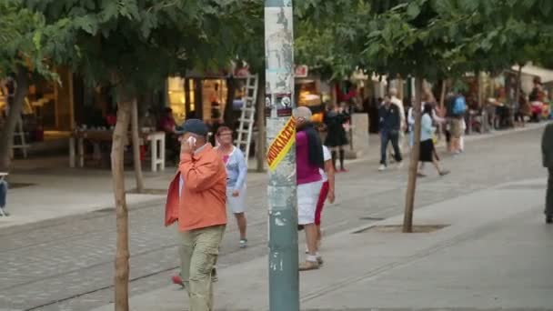 ATHENS, GREECE - JULY, 2014: People walking in the city. Many people walking resort city downtown on weekend, senior men talking on phone — Stock Video