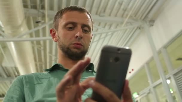 Young male typing message on smartphone, dialing number to make phone call — Stock Video