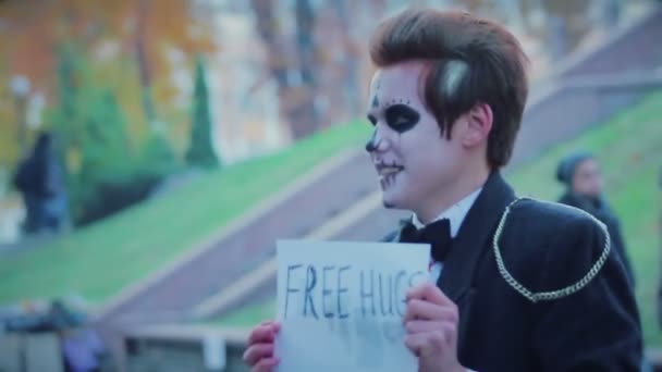 Guy en costume de zombie souriant, offrant des câlins gratuits aux gens dans la rue, spectacle de monstres — Video