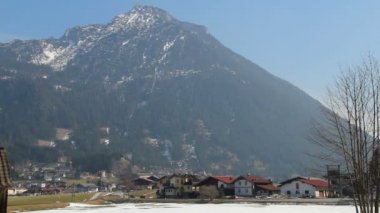 Görkemli Alp dağının dibinde küçük bir kasaba, özel evler, aktif trafik