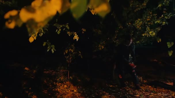 Galen man gå i mörka skogen med mordvapnet, offret som gömmer sig i buskarna — Stockvideo