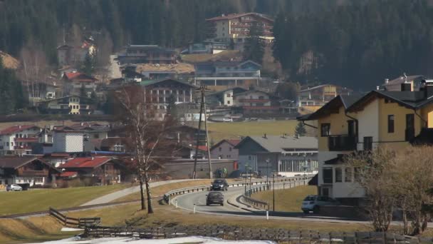 Tráfico activo en carretera en el fondo de la montaña, flujo turístico intensivo a la ciudad turística — Vídeos de Stock