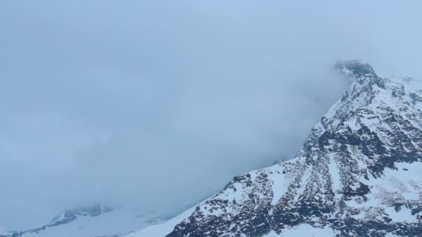 두꺼운 구름에 숨겨진 눈 덮인 산 봉우리, 일기 예보, 폭풍 경보 — 비디오