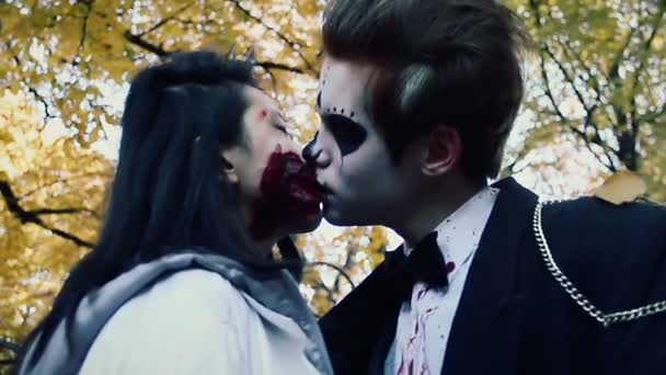 Casal jovem beijando na festa de Halloween, homem e mulher em ternos de zumbi se divertir — Vídeo de Stock