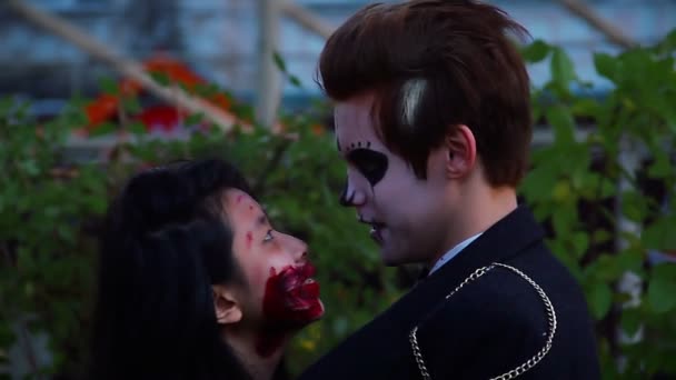Молодая пара обнимается, наслаждается вечеринкой на Хэллоуин, любовники разговаривают друг с другом — стоковое видео