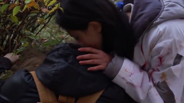 Cruel female vampire biting victim fiercely, drinking blood from person's neck — Stock Video