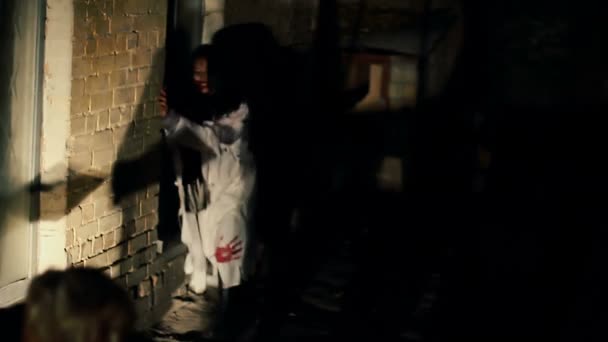 Hroznou zombie chůzi pomalu v temné uličce, hledá oběti v noci — Stock video