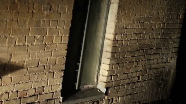 Lugar de miedo, ventana rallada en la pared de ladrillo viejo, edificio abandonado, guarida criminal — Vídeos de Stock
