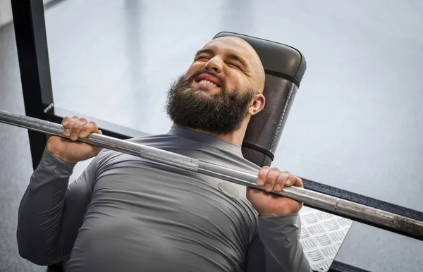 Strong man lifting weight in the gym, male athlete training at fitness club — Stock Photo, Image