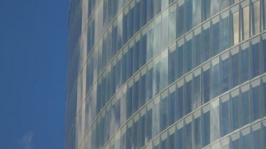 Parlak mavi gökyüzünün yansıması modern çok katlı binanın pencere bardaklarda