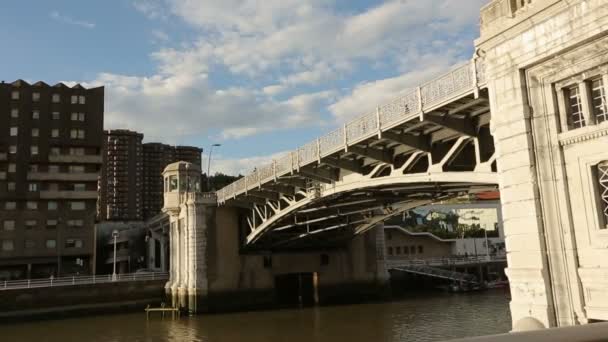 Люди ходят по старому каменному мосту через реку, промышленной архитектуры района — стоковое видео