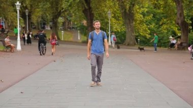Adam park çevresinde yürüyüş sırt çantası ile