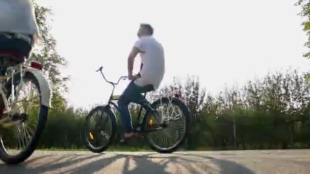 Dos amigos varones montando bicicletas rápido, divirtiéndose juntos, viviendo la vida activa — Vídeos de Stock