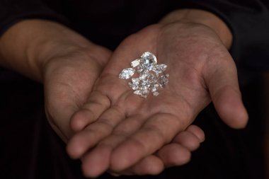 Güzel, lüks bir elmas tutan bir kuyumcu. Değerli taşları değerlendiriyorum. Elmas işi, endüstri. Gemoloji laboratuvarı incelemesi, pahalı ürünler testi..