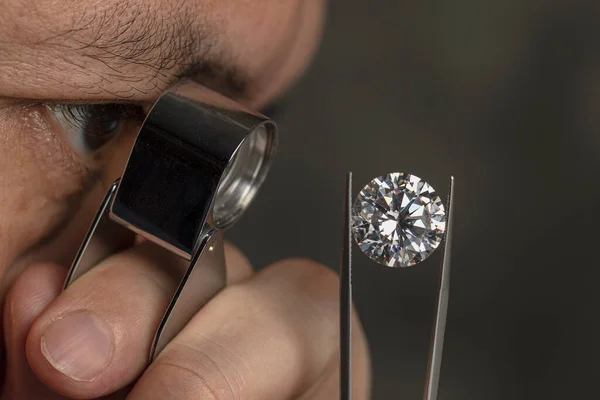 戴眼镜的人戴着珠宝 透过百叶窗望着钻石 天然钻石 光彩夺目宝石工业 切割和抛光的钻石 — 图库照片