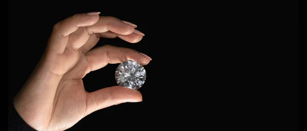 Man jeweller hand holding nice luxury diamond. Grading gem precious stones. Diamond business, industry. Gemology lab examination, expensive goods testing.