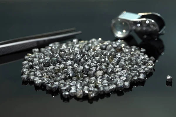 Rough industrial diamonds on black background. Row diamond material. Diamond for technical use. Diamond tools sourcing, cheap price goods.