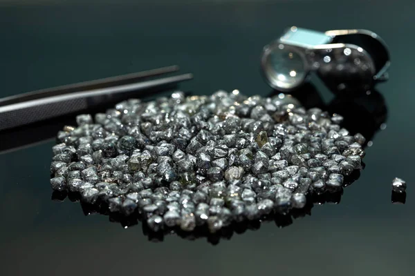 Rough industrial diamonds on black background. Row diamond material. Diamond for technical use. Diamond tools sourcing, cheap price goods.