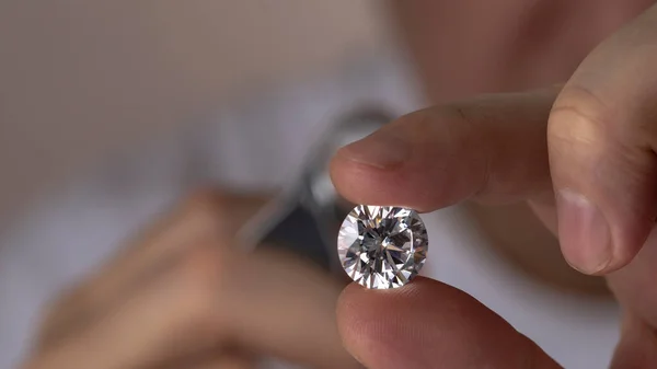 Jeweller asian man looking at diamond through magnifying glass. Diamond dealer evaluating and grading big size gem stone. — Stock Photo, Image