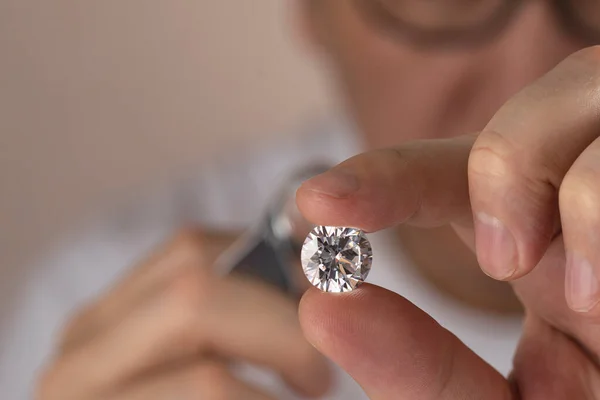 Joyero asiático hombre mirando diamante a través de lupa. Distribuidor de diamantes evaluar y clasificar piedra de gema de gran tamaño. — Foto de Stock