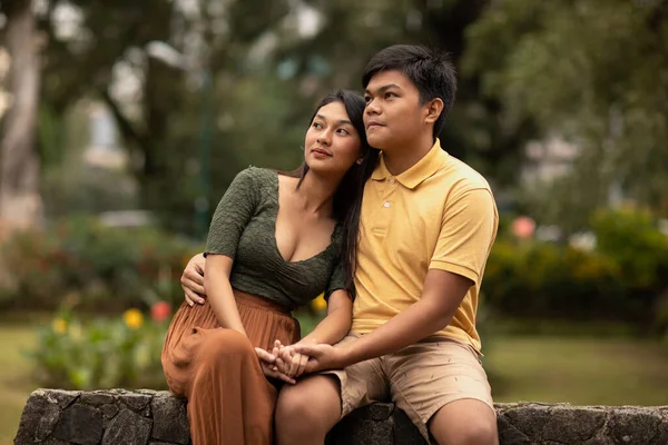 Genç ve güzel Asyalı çift parkta birlikte mutlu mesut yürüyorlar..