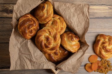 Ev yapımı çörekler hamur mayasından, kuru üzümler ve ahşap masa manzarasında kurutulmuş kayısılar..
