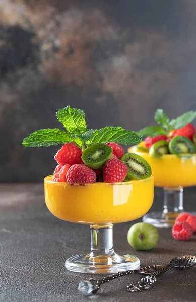 Közelkép a világos lédús mangó smoothie díszített bogyók és menta. Friss gyümölcsökből és bogyókból készült egészséges, ízletes élelmiszerek. — Stock Fotó