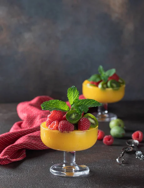 Közelkép a világos lédús mangó smoothie díszített bogyók és menta. Friss gyümölcsökből és bogyókból készült egészséges, ízletes élelmiszerek. — Stock Fotó