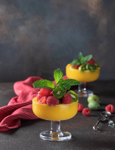 Meyve ve nane ile süslenmiş parlak sulu mangolu smoothie 'yi kapat. Taze meyve ve böğürtlenlerden yapılan sağlıklı ve lezzetli yemekler..