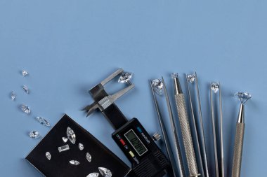 Elmas tüccarının işyerinde farklı boyutlarda elmaslar parlatılmış elmasları değerlendiriyor..