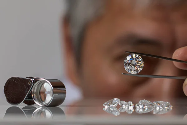 Primer plano de las manos de los distribuidores de diamantes que evalúan el diamante en la exposición internacional de joyas — Foto de Stock