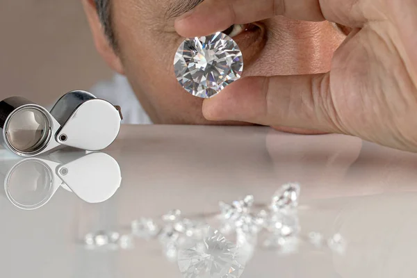 Närbild av diamant återförsäljare händer utvärdera diamant på internationella smycken utställning — Stockfoto
