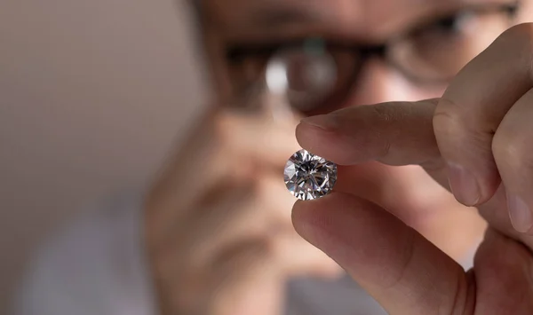 Close up of diamond dealers hands evaluating diamond at international jewelry exhibition — 图库照片