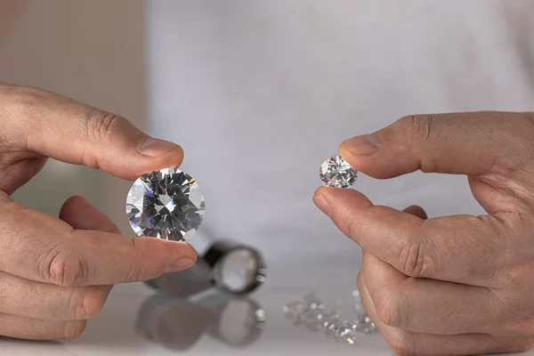 Close-up de mãos de negociantes de diamantes avaliando diamante na exposição internacional de jóias — Fotografia de Stock