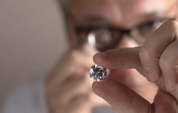 Close up of diamond dealers hands evaluating diamond at international jewelry exhibition — 图库照片