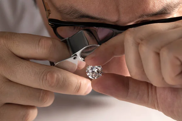 Close up of diamond dealers hands evaluating diamond at international jewelry exhibition — 图库照片