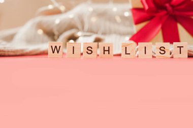 wish list lettering of square letters on background of shining garlands and gift with red satin fabric with empty space for text, selective focus