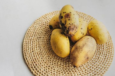 Birkaç çürümüş sarı mango, dokuma dokuma eko-peçetede çürük ve yatak yaraları. Yetersiz yiyecek depolama, seçici odaklanma