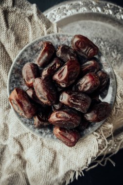 Geleneksel iftar akşam atıştırmalığı ve oryantal şekerlerle birlikte eski bir metal tabakta kurutulmuş hurmalar. sağlıklı doğal çerez. seçici odak