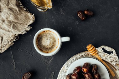 Yeni demlenmiş kahve ve koyu atmosferde kurutulmuş hurma ile doğu kahvaltısı. Doğulu tatlılar, bal balı çubuğu, tahıl çuval bezi, klasik yemekler. Doğulu tatil düzeni, seçici odak