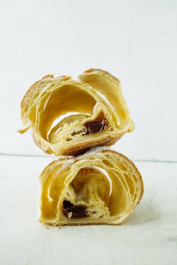 Yakın plan seçmeli ev yapımı kruvasan kesimi tatlı dolgulu ve hafif arkaplanlı pudra şekerli. Seviyelendirilmemiş hamur. çirkin hamur işleri.