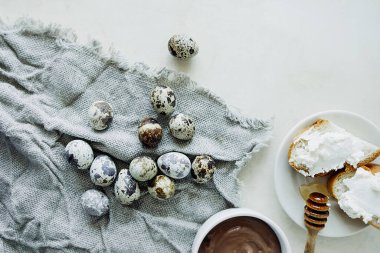 Sıcak Paskalya kahvaltısı, bıldırcın yumurtası, ev yapımı peynirli sandviç ve tabakta çikolatalı makarna. Ev tatili için şenlik masası. Basit tarifler. seçici odak