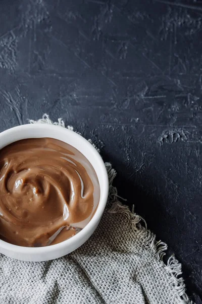 homemade chocolate pudding in white porcelain plate on dark background. homemade recipes for children. food content. chocolate paste texture . selective focus