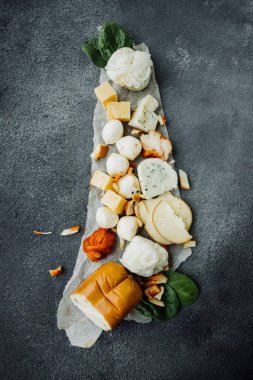 Değişik peynirlere sahip peynir panoları: mozzarella, Gürcü, süzme peynir, tütsülenmiş, parmesan, baharatlı, sert çeşitleri. Taze domates, bir fincan bal. Peynir menüsü dikey, seçici odaklanma