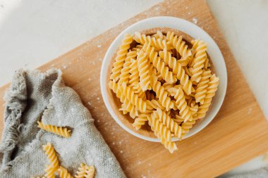 Spiral tortiglionili makarna. Parlak mutfakta. Buğdaydan yapılmış ev yapımı makarna. Un tabaklarını pişirme süreci. yiyecek içeriği, seçici odak