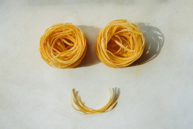 Ev yapımı Pappardelle Makarnası 'nın yemek yüzü temiz arka planda gülümsüyor. Çocuk makarnası tarifleri. seçici odak